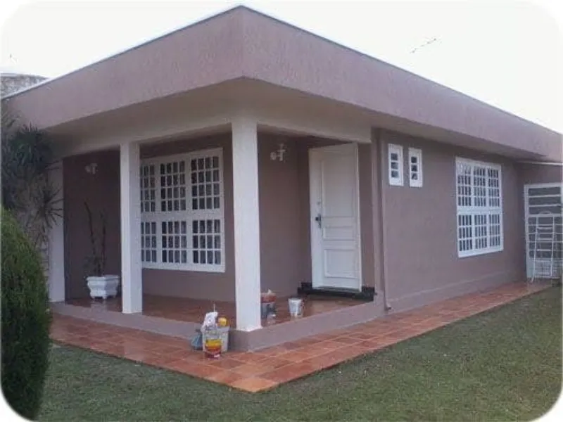 Fachada de casa pintada em marrom com acabamento claro